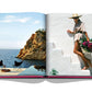 Open Ibiza Bohemia book featuring a photograph of a woman in a wide-brimmed hat and beige outfit, holding flowers on white steps overlooking a Mediterranean hot spot by Assouline.