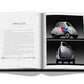 An open book displaying images and text about the BMW Isetta 250, featuring front and side views of a white car with blue and red stripes. The book, "Iconic: Art, Design, Advertising, and the Automobile" by Assouline, reminiscent of iconic automotive advertising, is placed on a white surface.