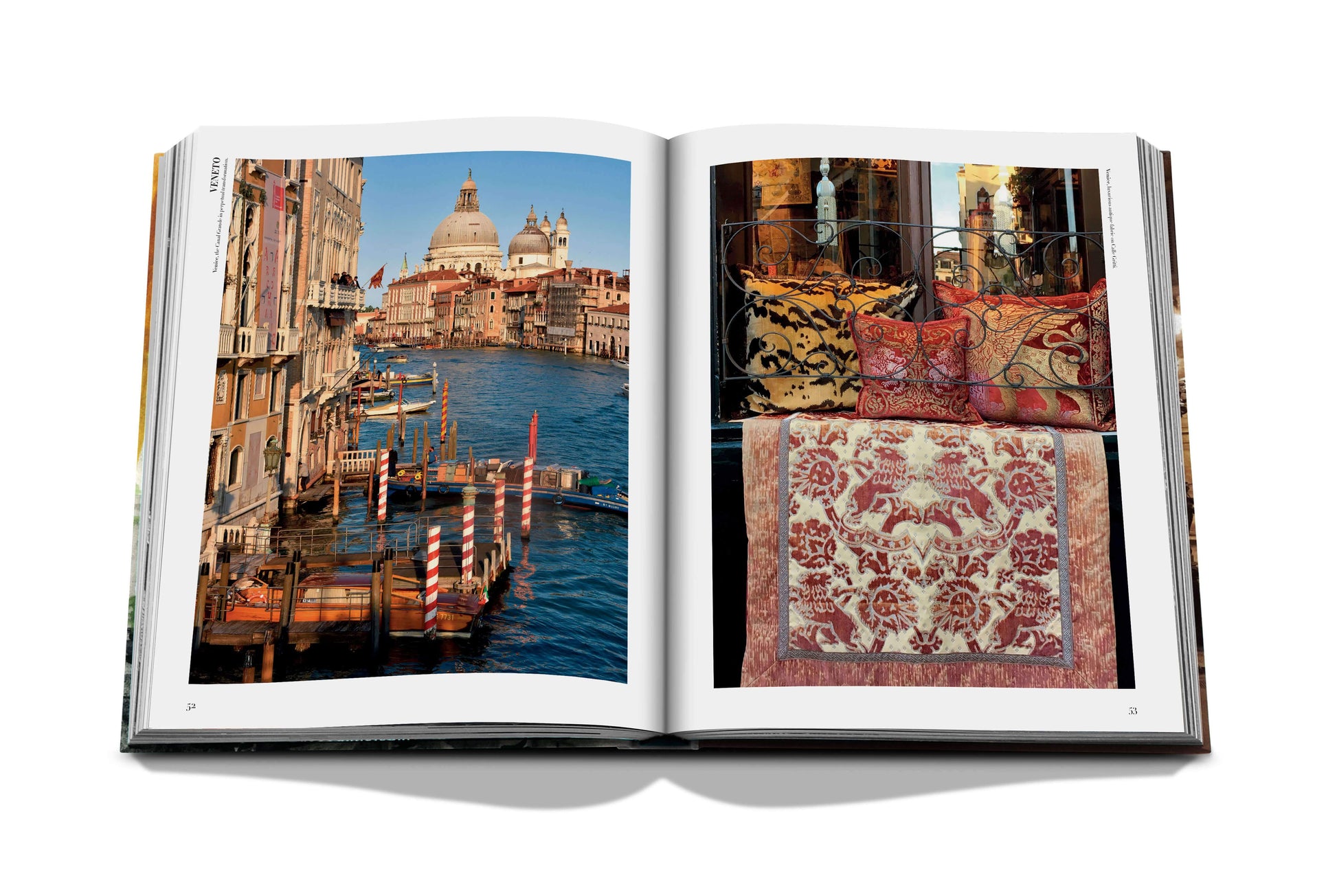 An open book, Italian Chic by Assouline, reveals a photograph of a canal in Venice on the left page and an image of patterned textiles and cushions on the right, capturing the timeless Italian style.