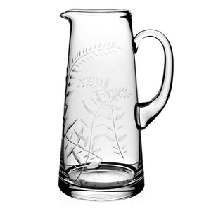 The William Yeoward Crystal Jasmine 4 Pint Pitcher features a clear glass body with a handle, spout, and an engraved leaf pattern, shown on a white background.