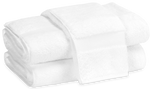 Two folded plush towels from the Matouk Lotus Bath Collection, White, made in Portugal from low-twist cotton, stacked against a plain background.