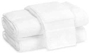 Two folded plush towels from the Matouk Lotus Bath Collection, White, made in Portugal from low-twist cotton, stacked against a plain background.