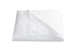 A neatly folded white Matouk Luca Hemstitch Bedding Collection bed sheet isolated on a white background.