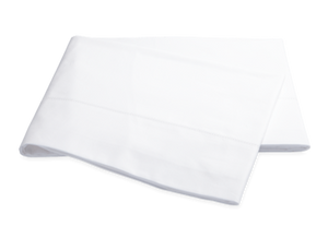 Folded white Matouk Luca Hemstitch Bedding Collection cloth napkin on a white background.