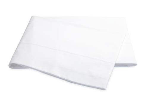 Folded white Matouk Luca Hemstitch Bedding Collection cloth napkin on a white background.