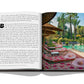 An open book displaying a printed image of a tropical resort inspired by Assouline's interpretation of Moroccan arts, with palm trees and a poolside area reminiscent of Marrakech culture.