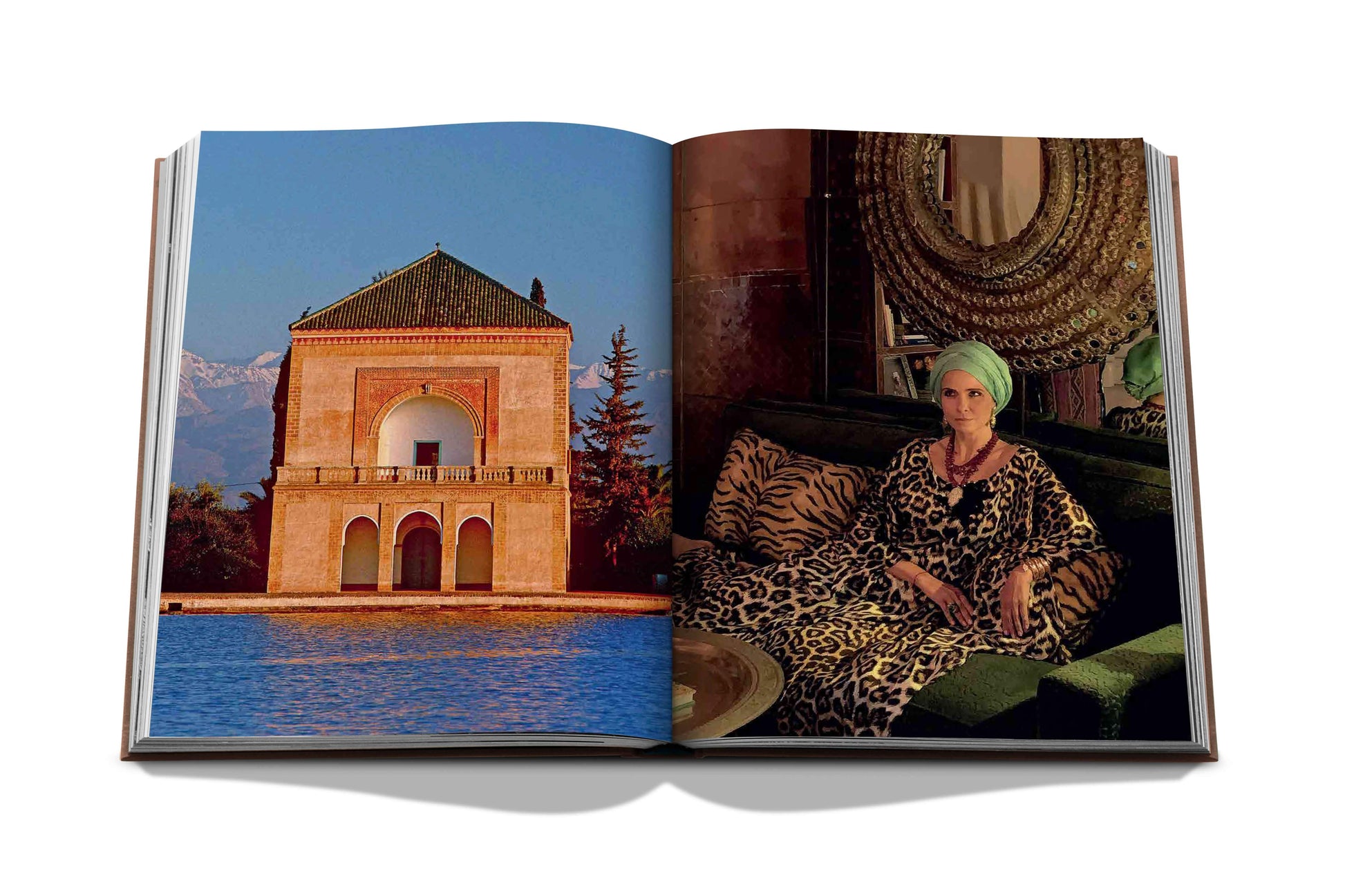 An open book displaying two photographs: on the left, a building beside a body of water with mountains in the background reflecting Marrakech Flair arts; on the right, a woman in a patterned dress. (Assouline)