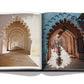 Open Marrakech Flair book displaying a photograph of an architectural corridor with arches in Marrakech, merging real and printed scenes by Assouline.