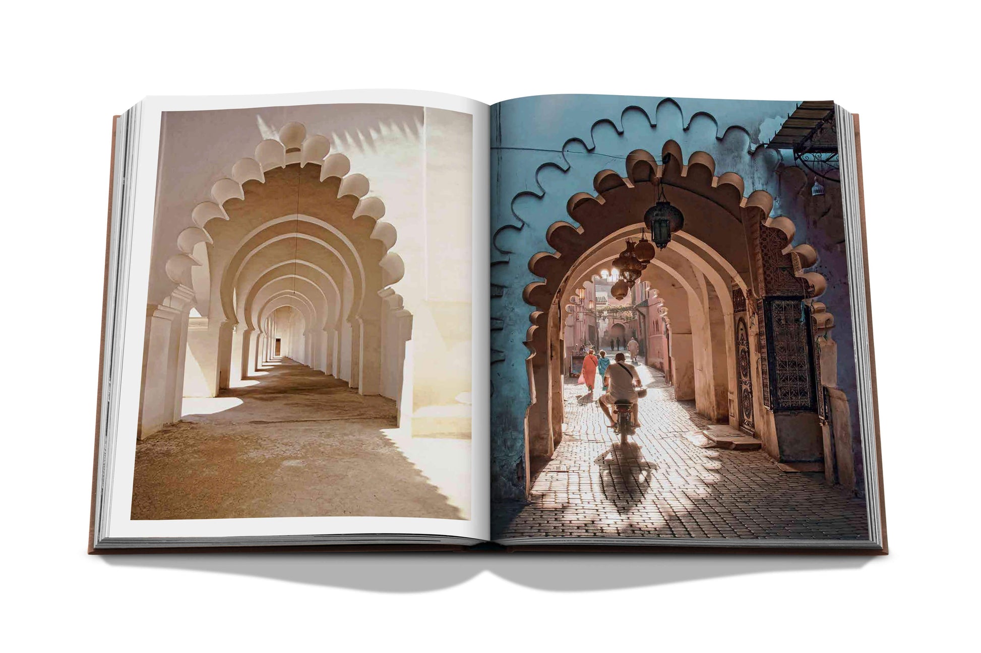 Open Marrakech Flair book displaying a photograph of an architectural corridor with arches in Marrakech, merging real and printed scenes by Assouline.