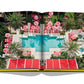 An open book with a pool and red umbrellas, perfect for Assouline Miami Beach life.