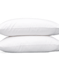 Two Matouk Milano Bedding Collection white pillows stacked on top of each other against a green background.