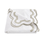 A folded white bed sheet from the Matouk Mirasol Bedding Collection in Silver, crafted from Egyptian cotton percale with a gray and white scalloped border design.