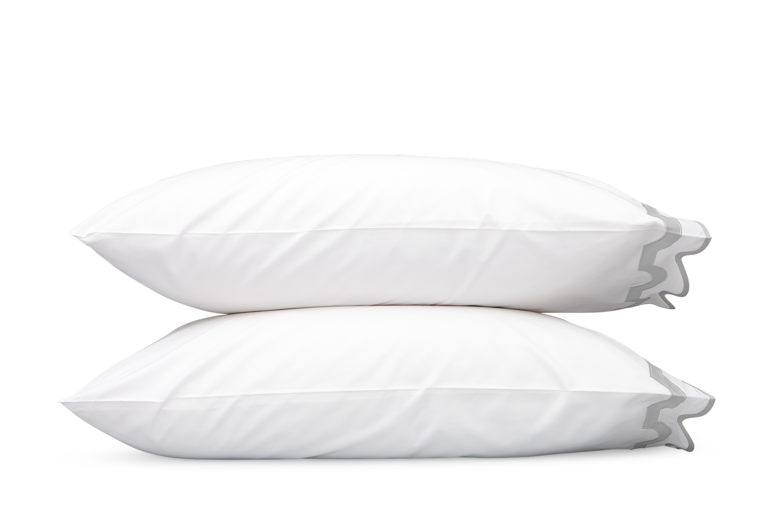 Two white pillows from the Matouk Mirasol Bedding Collection in Silver, crafted from Egyptian cotton percale with a 600 thread count, are stacked on top of each other against a plain gray background.