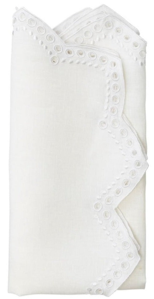 The Kim Seybert Eyelet Tapestry Napkin Set features folded white linen napkins with embroidered eyelet accents and delicate chevron-cut edges.