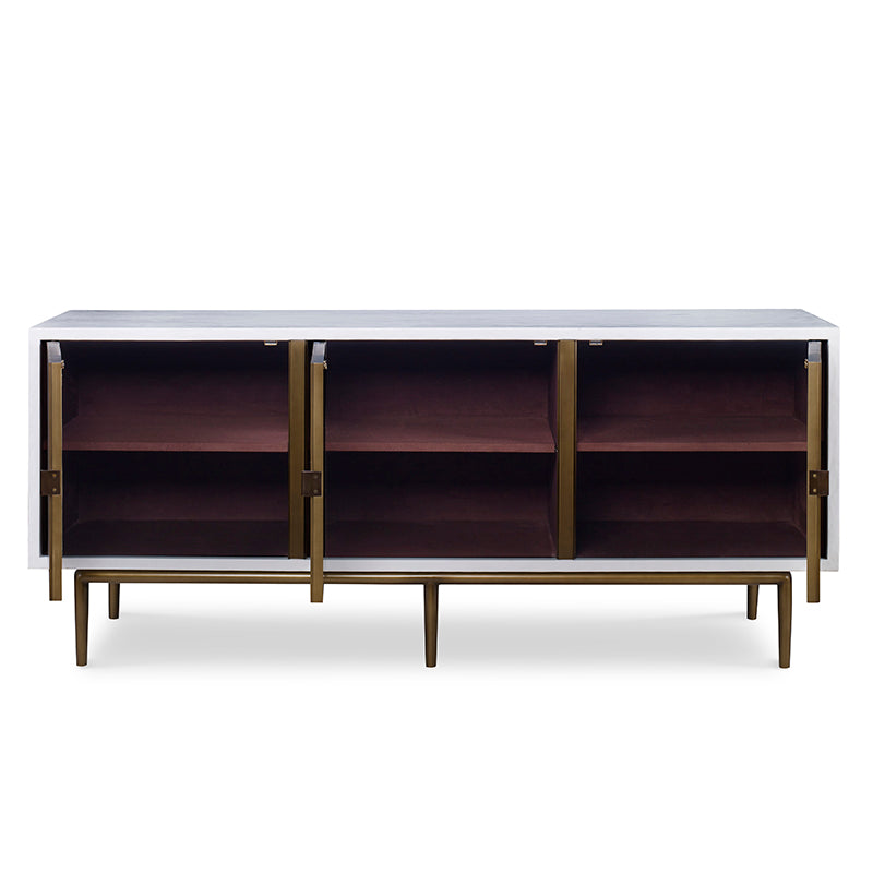 The Naples Cabinet by Mr Brown is a mid-century modern sideboard with three open wooden compartments and aged brass doors on slender legs. It features an empty interior, sleek dimensions, and a white smooth gesso finish that adds elegance.