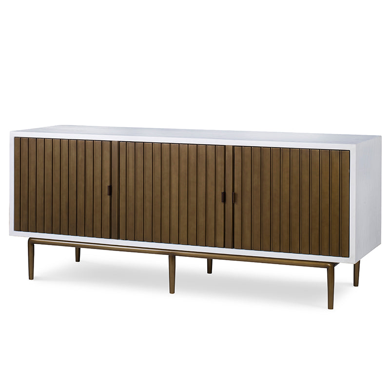 The Naples Cabinet by Mr Brown is a modern wooden sideboard with a sleek white frame. It features four vertically grooved doors finished in smooth white gesso and is raised on slim legs.