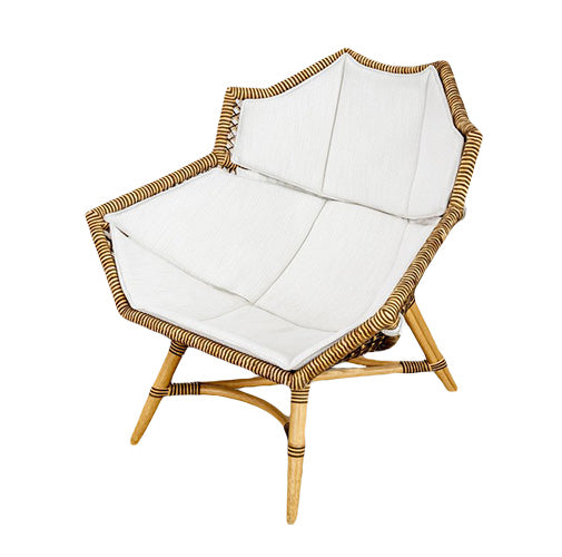 The McGuire Furniture Nozomu Lounge Chair is a hand-woven rattan chair designed with an artistic vision, featuring a white cushion.
