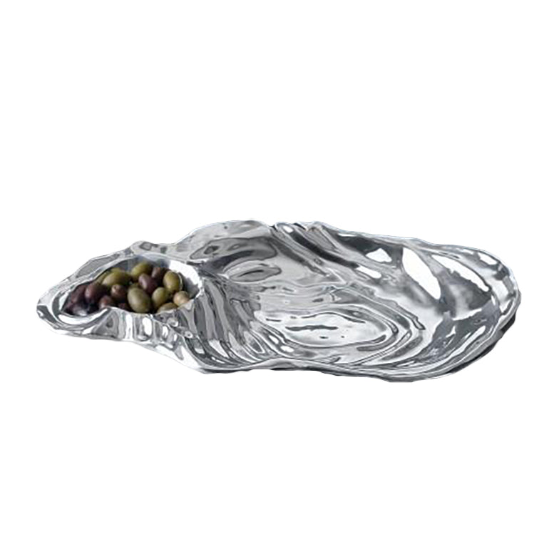 The Beatriz Ball Ocean Oyster Dip is a metallic serving tray with a sculptural oyster shell design and a small compartment ideal for assorted olives.