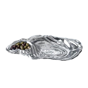 The Beatriz Ball Ocean Oyster Dip is a metallic serving tray with a sculptural oyster shell design and a small compartment ideal for assorted olives.
