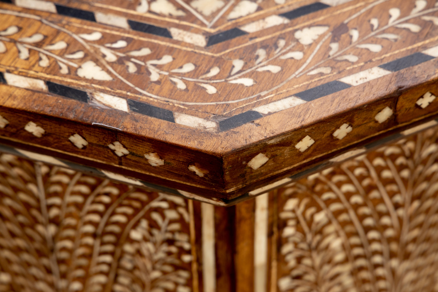 Close-up of the Bojay Large Octagon Side Table corner showcases intricate geometric and floral bone inlay patterns in contrasting light and dark tones.