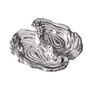 The Beatriz Ball Ocean Oyster Double Dip is a clear glass dish with an abstract organic shape, featuring two sections and a glossy finish, inspired by handmade artistry.
