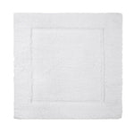 The Yves Delorme Prestige Blanc Bath Mat is a white rectangular mat with a subtle raised border, crafted from 100% cotton for plush comfort, shown from above on a plain background.