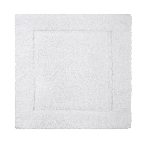 A plush Yves Delorme Prestige Bath Mat - Blanc with a non-slip backing on a white background.
