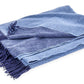 The Matouk Paley Cashmere Throw, featuring a folded oversized design in blue and light blue with fringed edges, enhances any room with comfort and style.