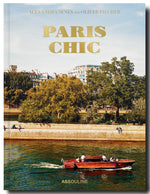 Cover of the 'Paris Chic' book by Assouline featuring a boat on the Seine River with sophisticated homes in Paris and Parisian architecture in the background.