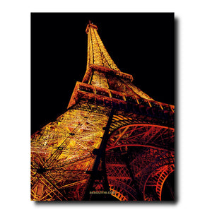 The Assouline Paris Chic illuminated at night, capturing the essence of Parisian life with a dark sky in the background.