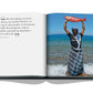 Open book showing a photo of a smiling man in sunglasses and a cap, standing in shallow water of the Red Sea and holding a large fish, with text describing a tropical location from "Red Sea: The Saudi Coast" by Assouline.