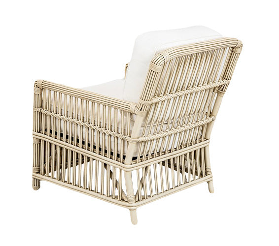 The PALECEK President's State Chair features a vintage design with delicate rattan accents, white cushions, an open weave pattern, and light wood finish, viewed from the rear.