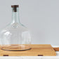 The Rectangle Oak Medium Charcuterie Board by etúHOME features a large clear glass cloche with a wooden knob, elegantly displayed against a light gray background.