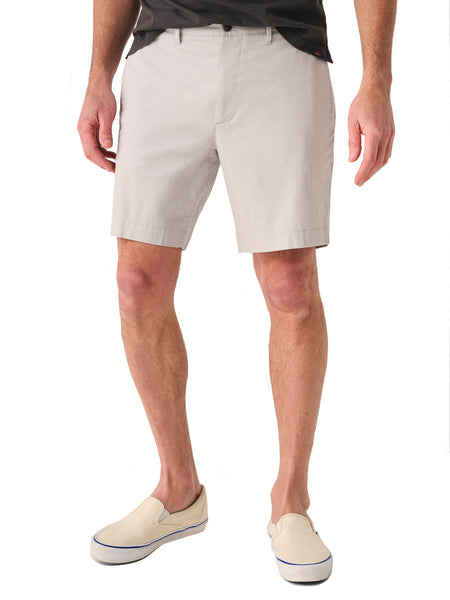 Man wearing Faherty Island Life Short 8" pants in light gray and white slip-on shoes from the brand Faherty, standing against a white background, visible from the waist down.