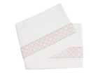 Two folded sheets from the HIVE Exclusive Rovella Bedding Collection in Salmon by Matouk, featuring a pink geometric lattice edge and crafted from Egyptian cotton percale, displayed on a white background.