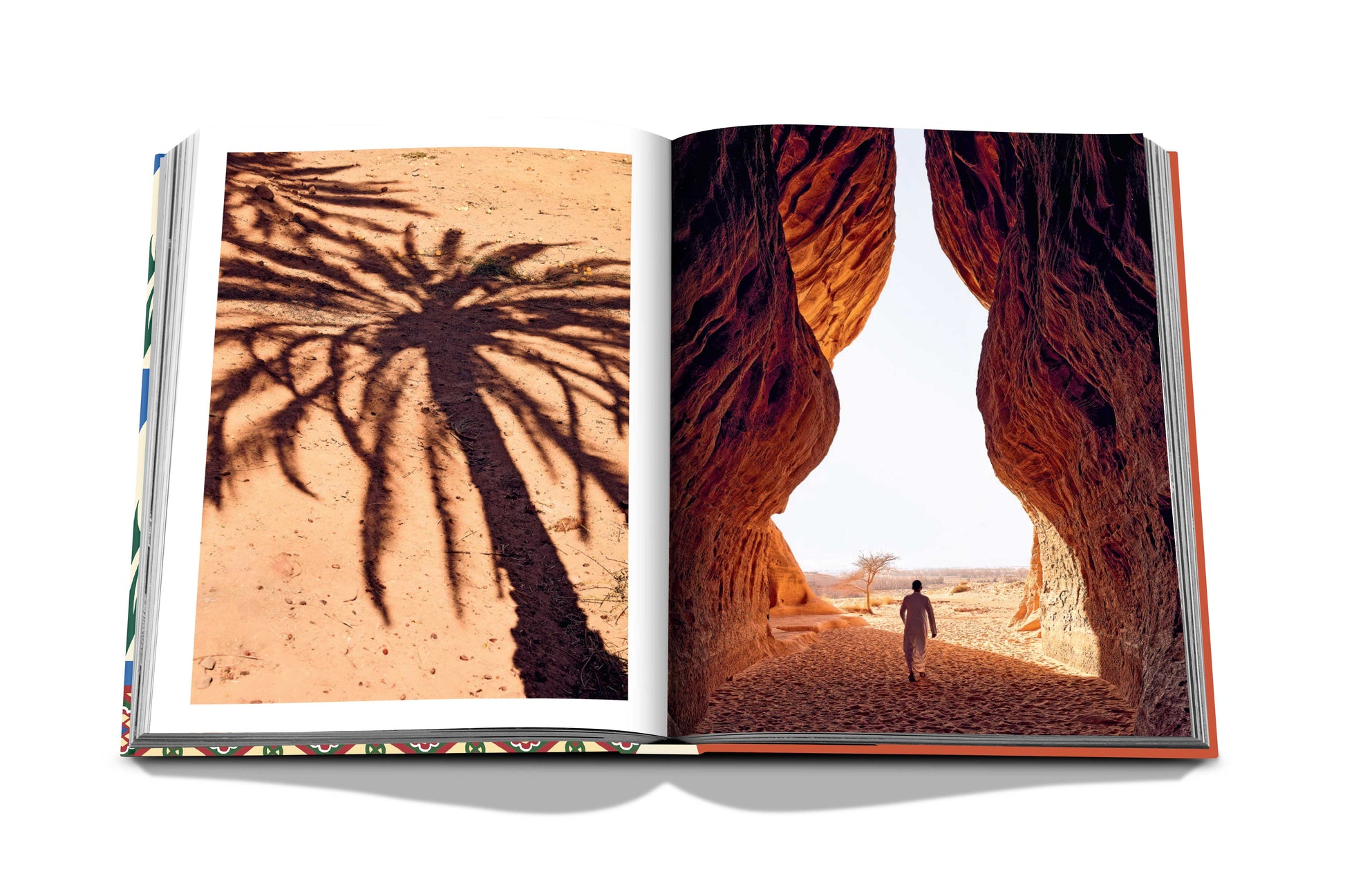 An open book featuring two pages with photographs of desert landscapes; on the left, a shadow of a dates palm tree cast across the sand, and on the right, a person standing between rock formations in "Saudi Dates: A Portrait of the Sacred Fruit" by Assouline.