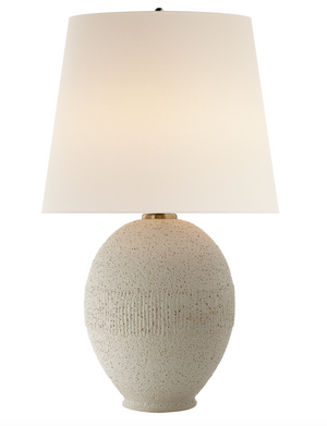 The Toulon Table Lamp by Visual Comfort in Volcanic Ivory showcases an oval base crafted from textured white ceramic, complemented by a broad, white lampshade. It includes an E26 Dimmer that supports up to 75 watts, providing both elegance and customizable lighting ambiance.