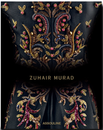 The Zuhair Murad fabric by Assouline showcases gold and red floral embroidery with exquisite handcrafted beading, featuring "ZUHAIR MURAD" at the center and "ASSOULINE" at the bottom.