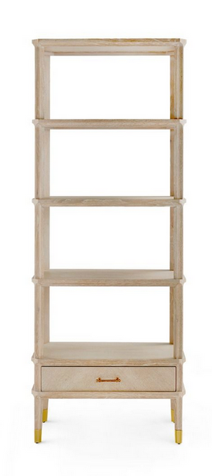 A tall wooden Bungalow5 Bertram Etagere bookshelf in Cerused Oak with five open shelves and a drawer at the bottom, featuring gold-finished feet.