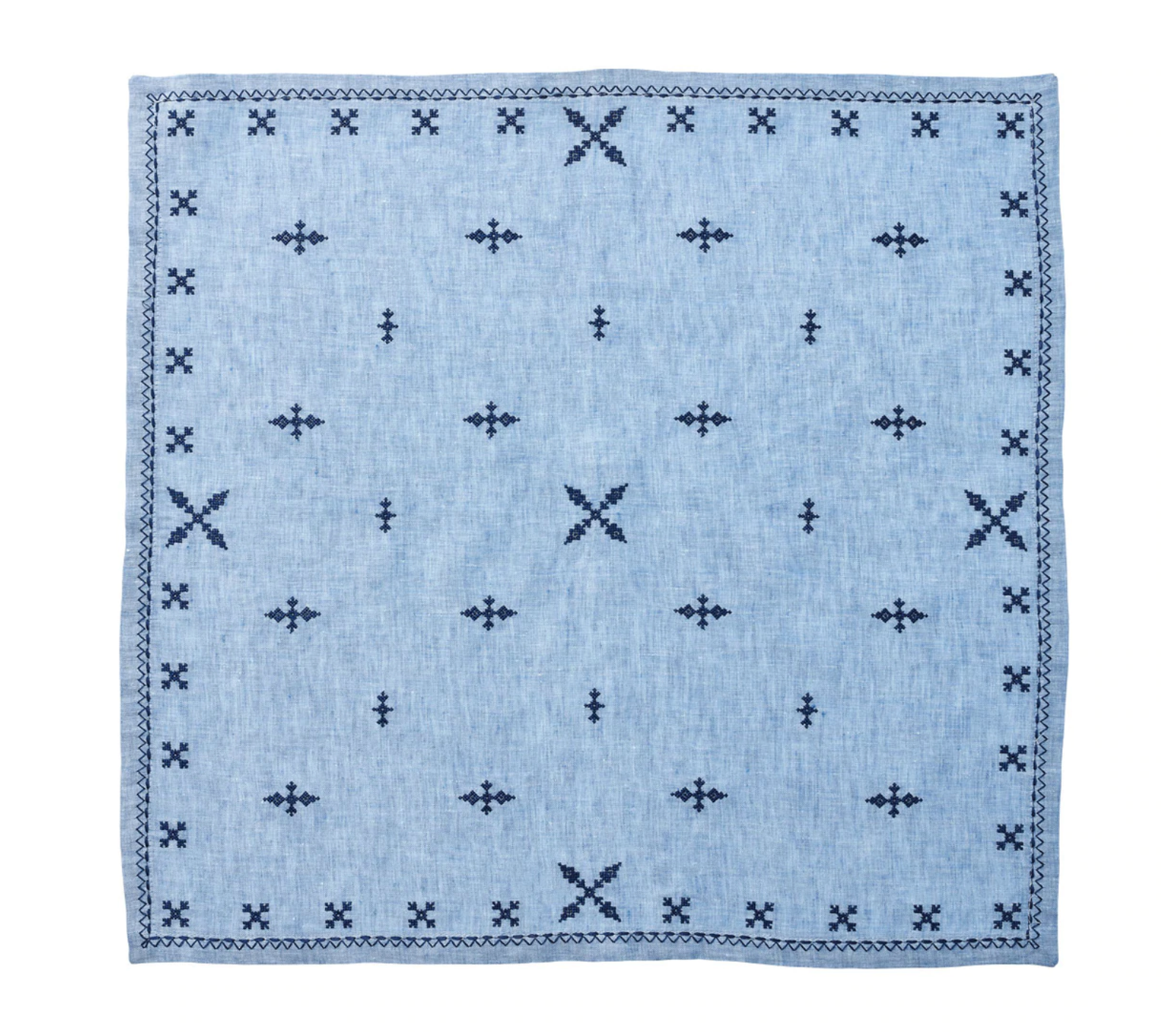 The Fez Periwinkle Napkin Set by Kim Seybert features square, light blue linen napkins with navy geometric embroidery and a repeating border inspired by Moroccan designs.
