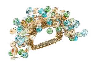 The Kim Seybert Spritz Natural/Seafoam Napkin Ring features clusters of seafoam-toned glass and pearl-like beads in blue, green, peach, and white for a gold-accented, hand-beaded look.