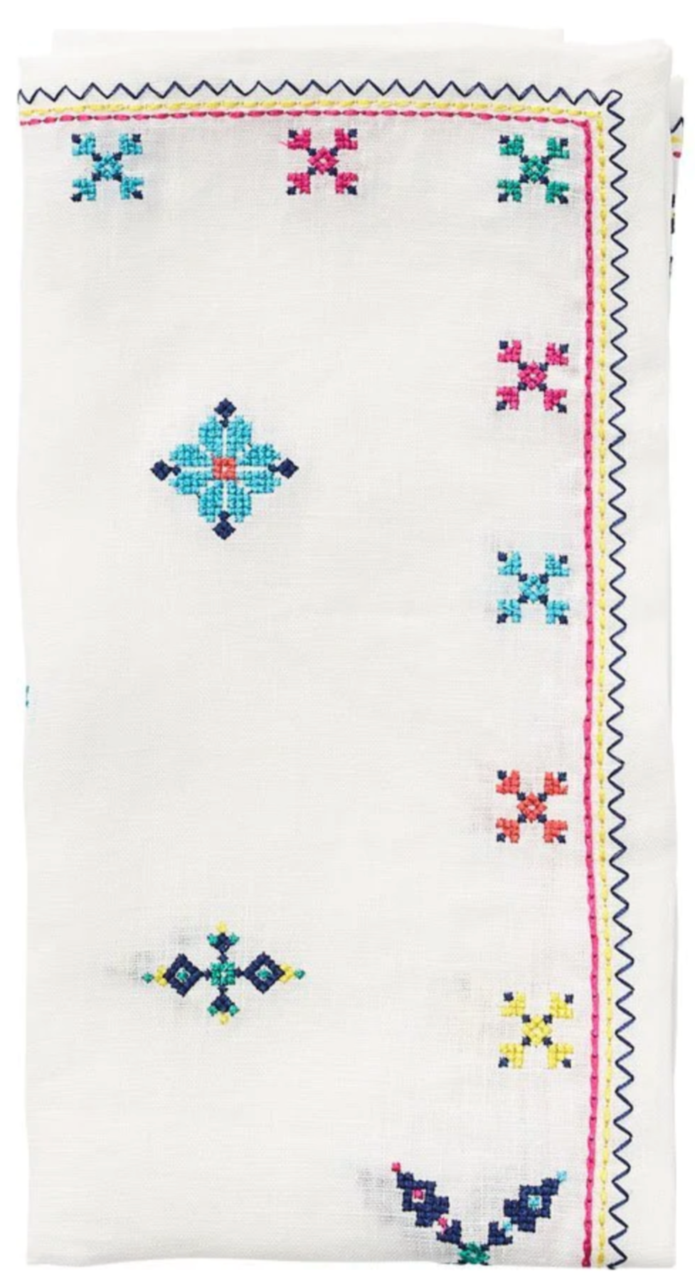 The Fez White/Multi Napkin Set by Kim Seybert features white linen napkins with colorful embroidered geometric and floral designs inspired by Moroccan embroidery on the edges and corners.
