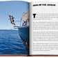 Open Greek Islands book featuring an article on "gems of the Aegean Sea" with a photograph of a person climbing the mast of a sailing boat on the left page by Assouline.