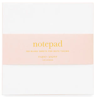 The Sugar Paper Painted Pad in Pink, featuring a white notepad with a pink band and labeled with "notepad" and "150 blank sheets for note taking," is an everyday essential from Sugar Paper, Los Angeles. It's perfect for on-the-go notes and makes jotting down ideas effortless wherever you are.