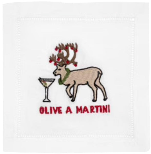 A white napkin from the August Morgan Cocktail Napkins Olive A Martini, Set of 4 by August Morgan features an embroidered reindeer with Christmas light-covered antlers beside a martini glass, accompanied by the text "Olive A Martini," all on classic hemstitching.