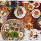 A table set with various dishes, such as sandwiches, scones, fruit, and nuts, elegantly adorned with a floral centerpiece and the Juliska Together at the Table tea service by Juliska, beautifully celebrates life's moments.