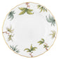 The Herend Foret Garland Collection features a white porcelain plate with a scalloped edge, gold trim, and hand-painted green leaves with pink accents, highlighting the brand's classic artistry.