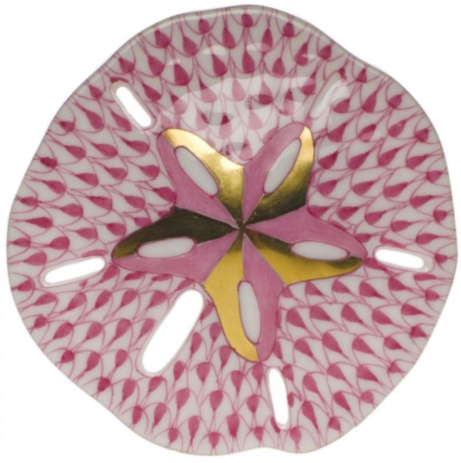 The Herend Sand Dollar is a decorative porcelain plate featuring a pink geometric pattern and gold accents, with exquisite hand-painted designs for true artistic appreciation.