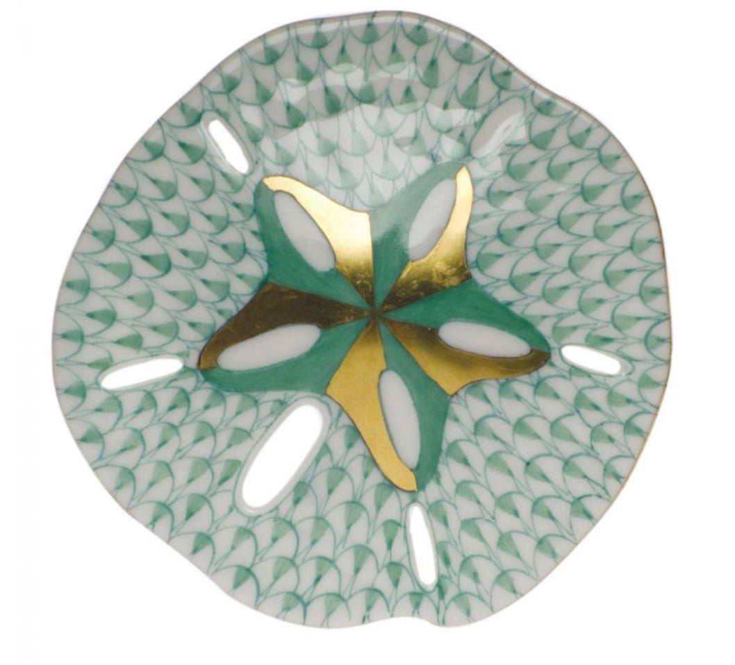 The Herend Sand Dollar porcelain plate features green and white scalloped edges, a gold and green star center, and oval cut-outs—an artistic decorative piece.