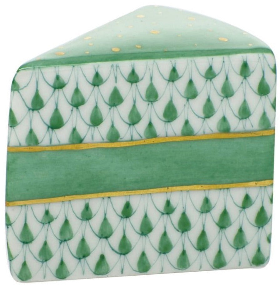 The Herend Slice of Cake is a ceramic piece shaped and painted to look like a cake slice, featuring green and gold hand-painted designs that highlight artistic craftsmanship.